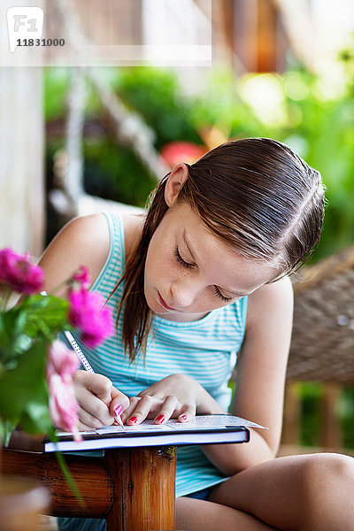Mädchen schreibt auf Notizblock im Freien