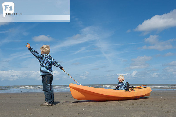 Brüder  die ein Kanu am Strand navigieren