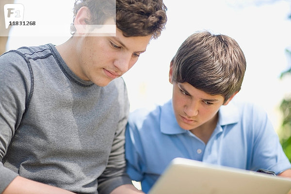 Jungen im Teenageralter benutzen gemeinsam einen Laptop