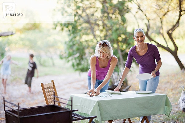 Frauen decken den Tisch im Freien