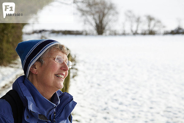 Glückliche Rentnerin in einem Schneefeld