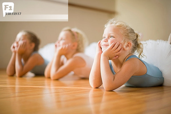 Auf dem Boden liegende Mädchen im Ballettunterricht