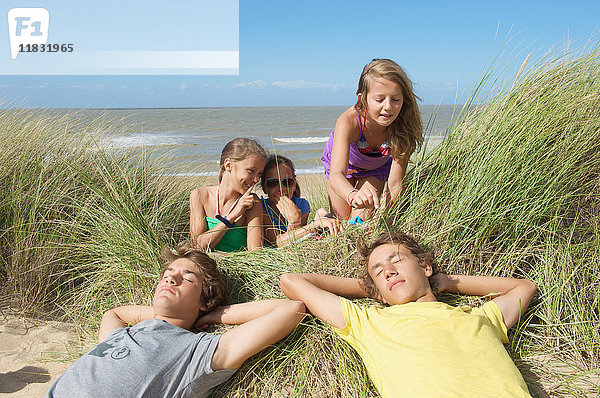 Mädchen necken Jungen in Sanddüne