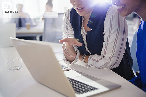 Geschäftsfrauen beim Reden  Arbeiten am Laptop im Büromeeting