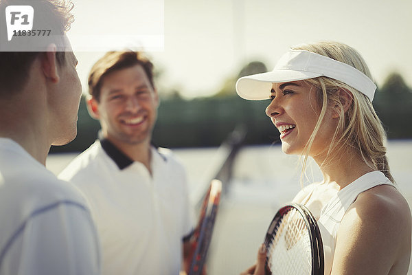 Tennisspielerinnen und -spieler im Gespräch auf dem Tennisplatz