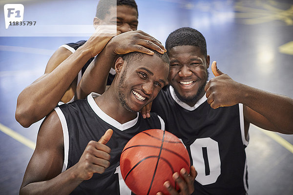 Portrait lächelndes  selbstbewusstes  junges Basketballteam feiert  Daumen hoch gestikulierend