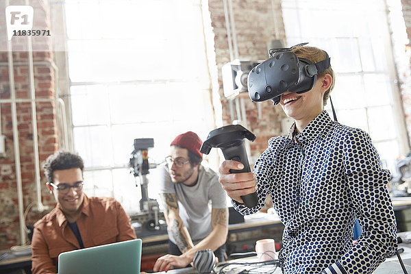 Designerinnen texten Virtual-Reality-Simulator-Brille und verwenden Joystick in der Werkstatt