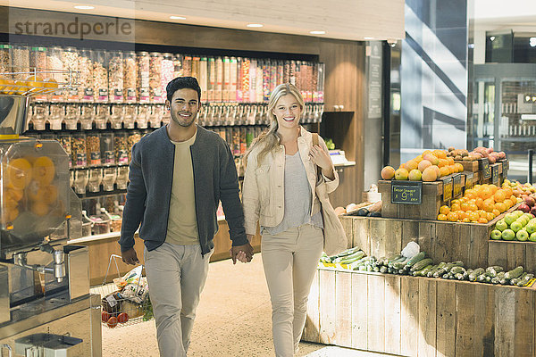 Porträt junges Paar  das sich an den Händen hält  Einkaufen auf dem Markt