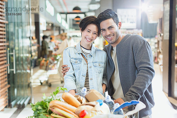 Portrait lächelndes junges Paar beim Einkaufen auf dem Markt