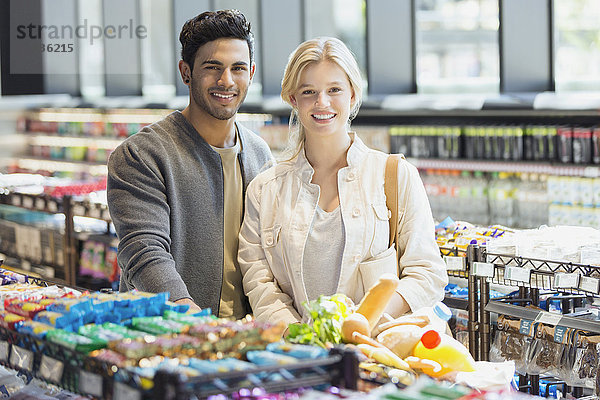 Portrait lächelndes junges Paar beim Einkaufen auf dem Markt