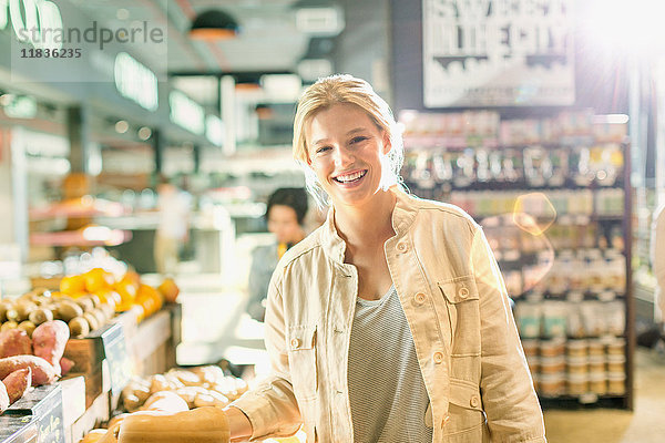 Portrait lächelnde junge Frau beim Einkaufen auf dem Markt