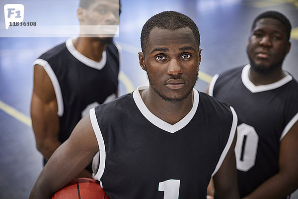 Porträt seriöse  fokussierte junge Basketballer-Mannschaft in schwarzen Trikots