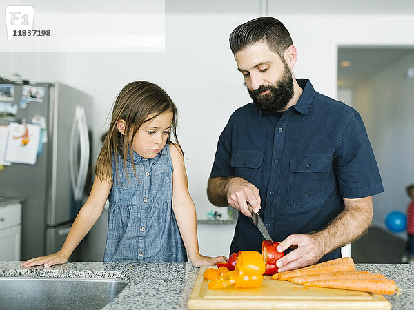 Vater mit Tochter (6-7) beim gemeinsamen Kochen