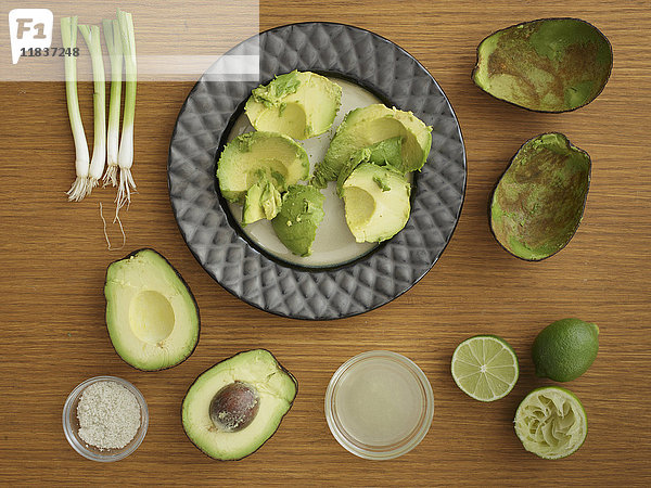 Studioaufnahme von Avocado  Limette und Frühlingszwiebeln für Guacamole