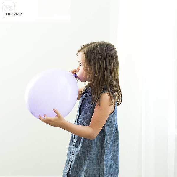 Mädchen (6-7) bläst Luftballon auf