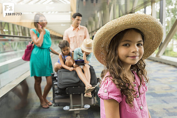 Porträt eines Mädchens  das mit seiner Familie im Flughafen wartet