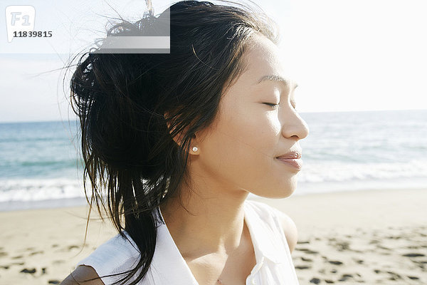 Porträt einer vietnamesischen Frau am Strand mit geschlossenen Augen