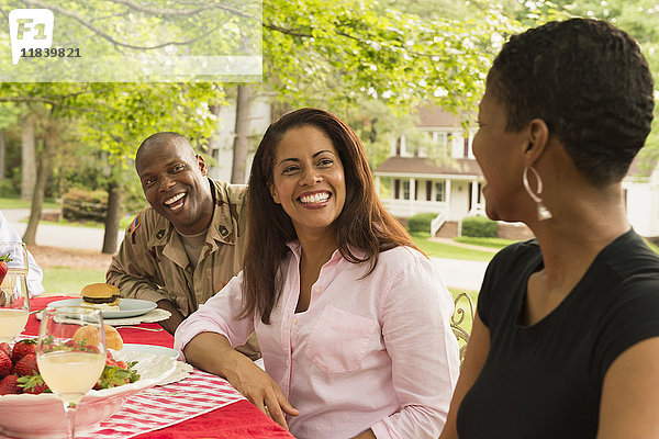 Afroamerikanischer Mann und Frauen lachen beim Picknick