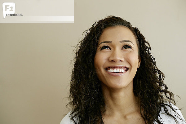 Porträt einer lächelnden gemischtrassigen Frau  die nach oben schaut