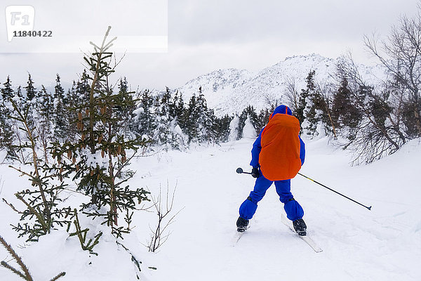 Kaukasischer Mann beim Skilanglauf in der Nähe eines Berges