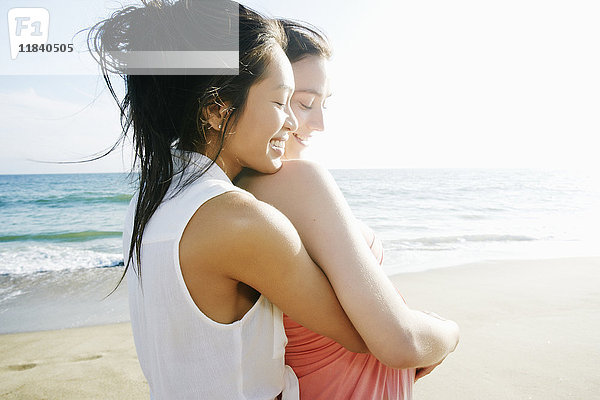 Frauen umarmen sich am Strand