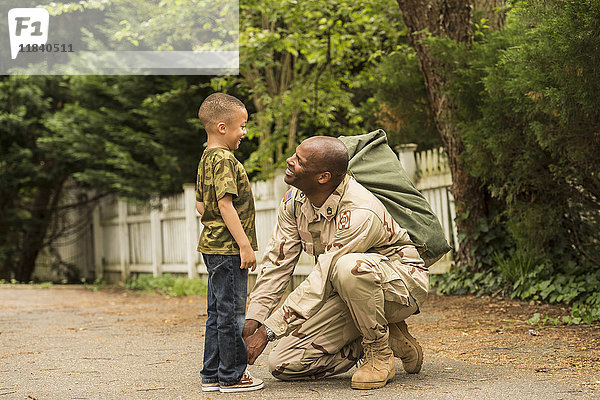 Afroamerikanischer Soldat bindet Schnürsenkel für Sohn