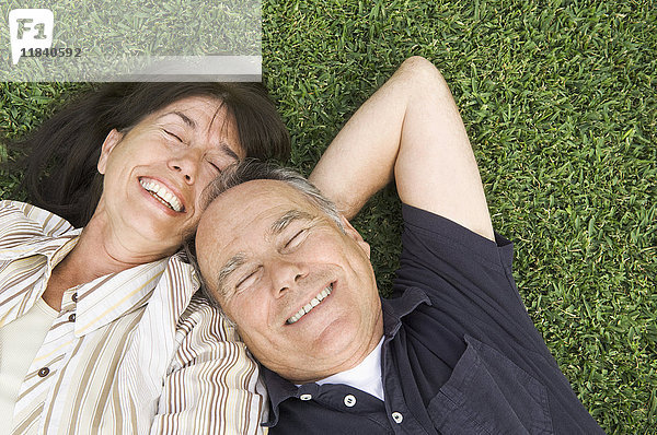 Älteres Paar liegt im Gras