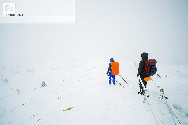 Kaukasische Wanderer mit Skiern auf dem Berg