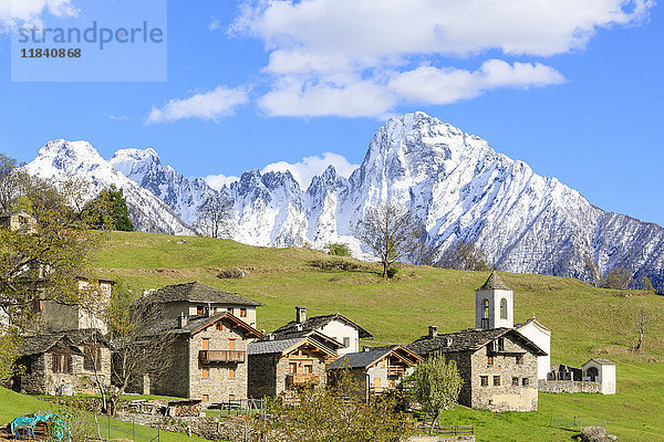 Alpendorf und Wiesen umrahmt vom schneebedeckten Gipfel des Pizzo di Prata  Daloo  Chiavenna-Tal  Valtellina  Lombardei  Italien  Europa