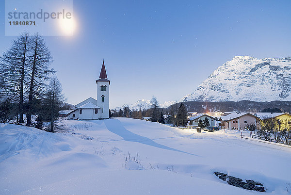 Lichter der Abenddämmerung auf Chiesa Bianca und Alpendorf mit Schnee bedeckt  Maloja Pass  Engadin  Kanton Graubünden  Schweiz  Europa