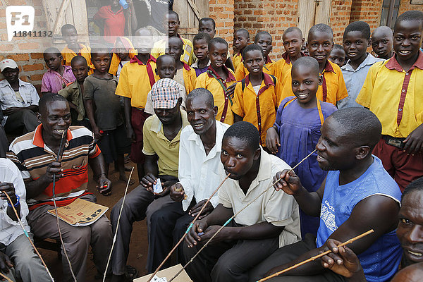 Ugandische Dorfbewohner  die selbst gebrautes Bier trinken  und Schulkinder  Bweyale  Uganda  Afrika