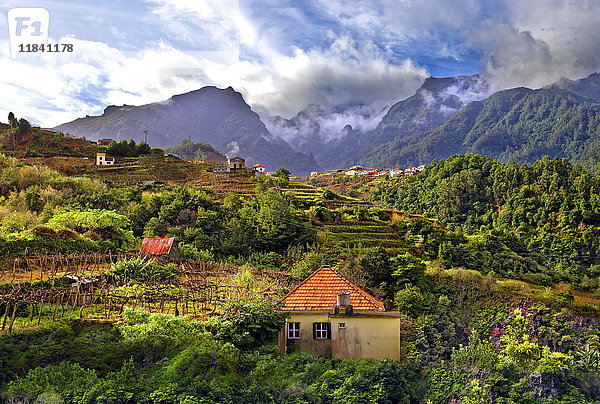 Erhöhter Blick auf ein Dorf und baumbewachsene Hügel und Berge bei Lameiros  in der Nähe von Sao Vicente  Madeira  Portugal  Atlantik  Europa