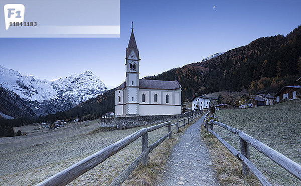 Kirche von Trafoi in der eisigen Dämmerung mit Mond am Himmel  Trafoi  Nationalpark Stilfser Joch  Südtirol  Italien  Europa