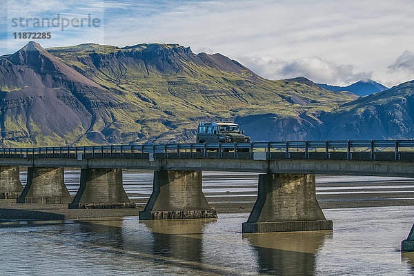 Fahrzeug fährt über eine Brücke an der Südküste von Island; Island'.