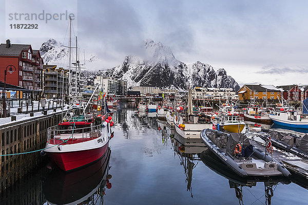 Boote in einem Hafen mit zerklüfteten Bergen entlang der Küstenlinie; Svolvar  Lofoten  Nordland  Norwa'.