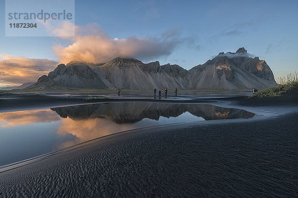 Menschen  die die wunderschöne Landschaft von Stokknes oder Vestrahorn bei Sonnenuntergang an der Südostküste Islands fotografieren; Island'
