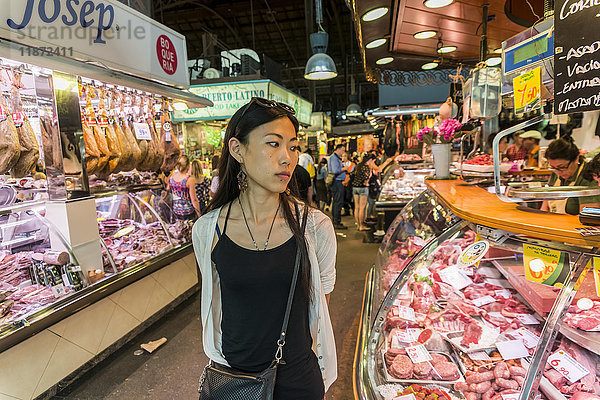 Eine junge Chinesin kauft auf dem Boqueria-Markt ein  einem der berühmtesten Märkte in ganz Spanien und dem berühmtesten in Barcelona; Barcelona  Katalonien  Spanien.