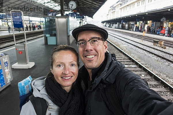 Ein Paar steht und nimmt ein Selbstporträt im Bahnhof von Lausanne auf; Lausanne  Schweiz'.