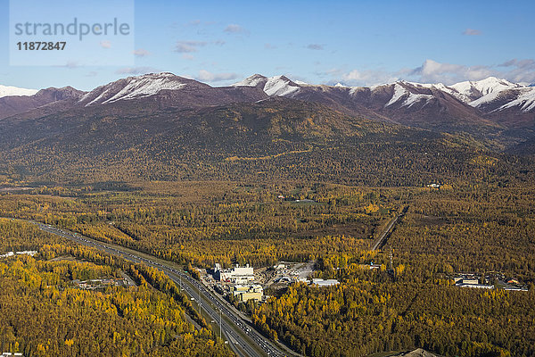 Luftaufnahme des Glenn Highway  der am Municipal Light and Power Power Plant vorbeiführt  mit den Chugach-Bergen im Hintergrund  Southcentral Alaska  USA
