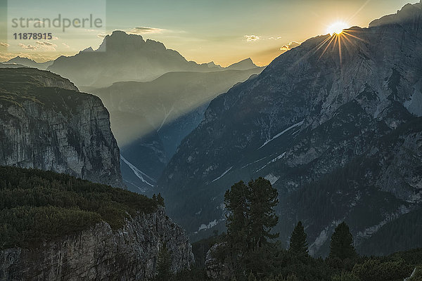Die untergehende Sonne scheint durch die Dolomiten im Nationalpark der Drei Zinnen; Italien'.