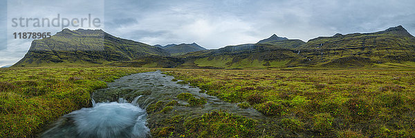 Panoramablick auf einen Schmelzwasserstrom  der aus den Bergen entlang der Südküste Islands kommt; Island'.