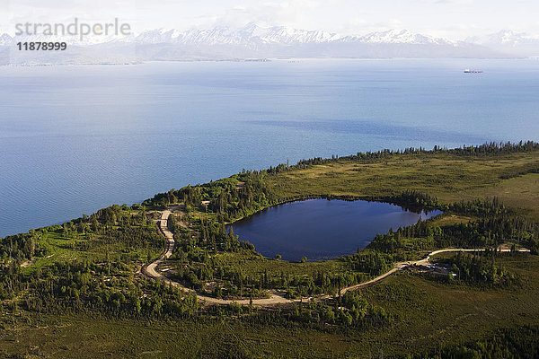Ein See und eine kurvenreiche Straße an der Kachemak Bay mit Blick auf die Kenai Mountains  Kachemak Bay State Park; Homer  Alaska  Vereinigte Staaten von Amerika'.