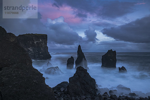 Der Sonnenuntergang färbt den Himmel über der tosenden Brandung an der Spitze der Halbinsel Reykenanes; Island'.