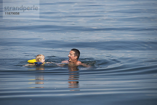 Ein junges kaukasisches Mädchen schwimmt mit ihrem Vater im Seneca-See  Upstate New York; Dresden  New York  Vereinigte Staaten von Amerika