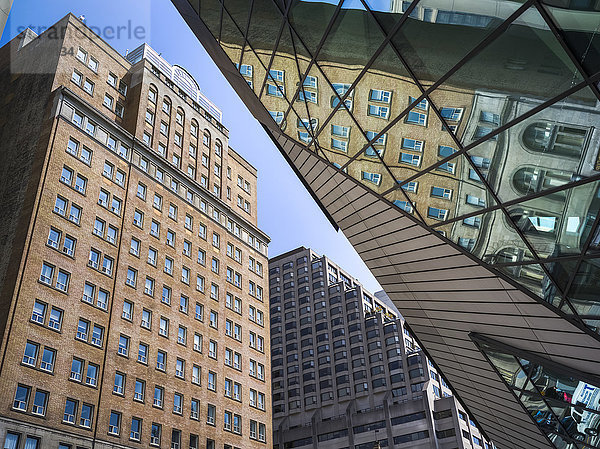 Niedriger Blickwinkel auf Gebäude und eine Spiegelung in der Glasfassade des Royal Ontario Museum; Toronto  Ontario  Kanada'.