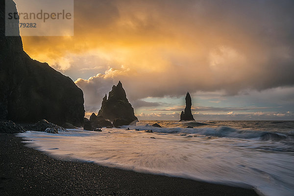 Die als Reynisdrangar bekannten Meeresstapel mit Wellen bei Sonnenaufgang  Südküste; Island'.