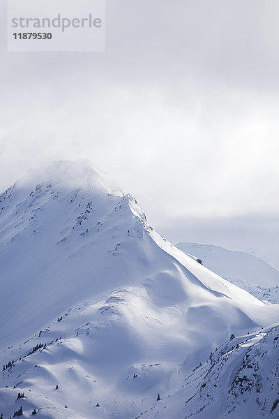 Schneebedeckte Gipfel der Kenai Mountains unter Wolken  Kachemak Bay State Park; Alaska  Vereinigte Staaten von Amerika'.