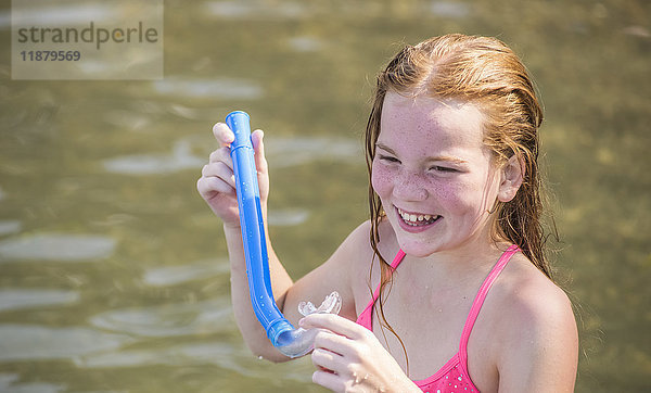 Ein 10-jähriges kaukasisches Mädchen mit roten Haaren spielt mit einem Schnorchel beim Schwimmen im Seneca Lake im Bundesstaat New York; Dresden  New York  Vereinigte Staaten von Amerika'.