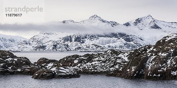 Schneelandschaft mit zerklüfteten Bergen und Meereswasser; Nordland  Norwegen'.