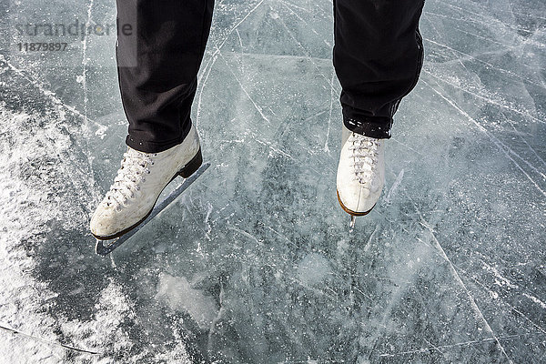 Hochformatige Ansicht und Nahaufnahme von weißen Schlittschuhen auf dem Eis; Calgary  Alberta  Kanada